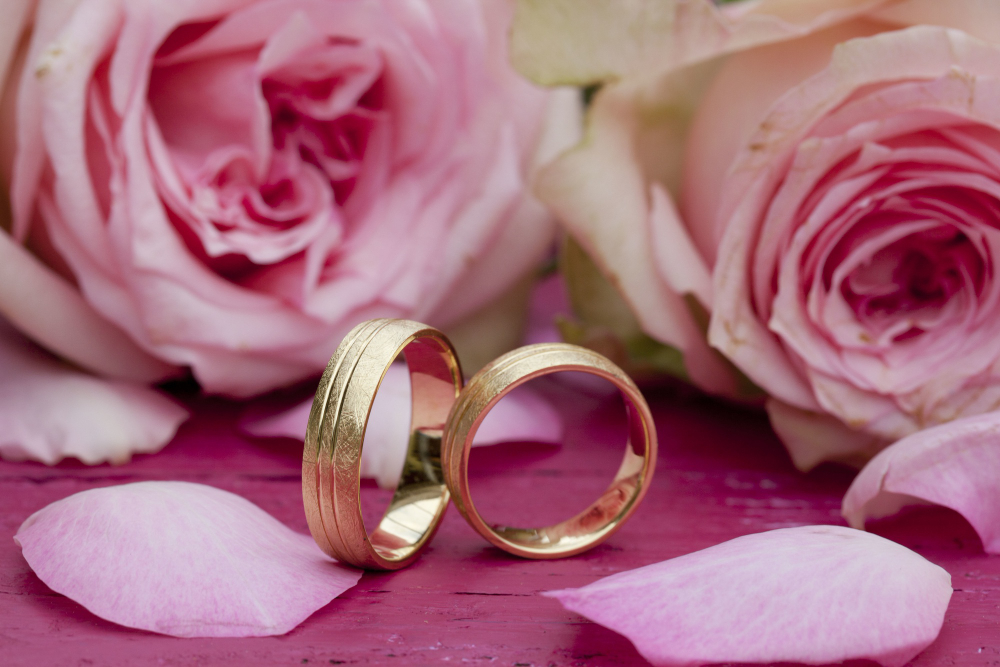 closeup-shot-engagement-rings-with-beautiful-pink-roses-table